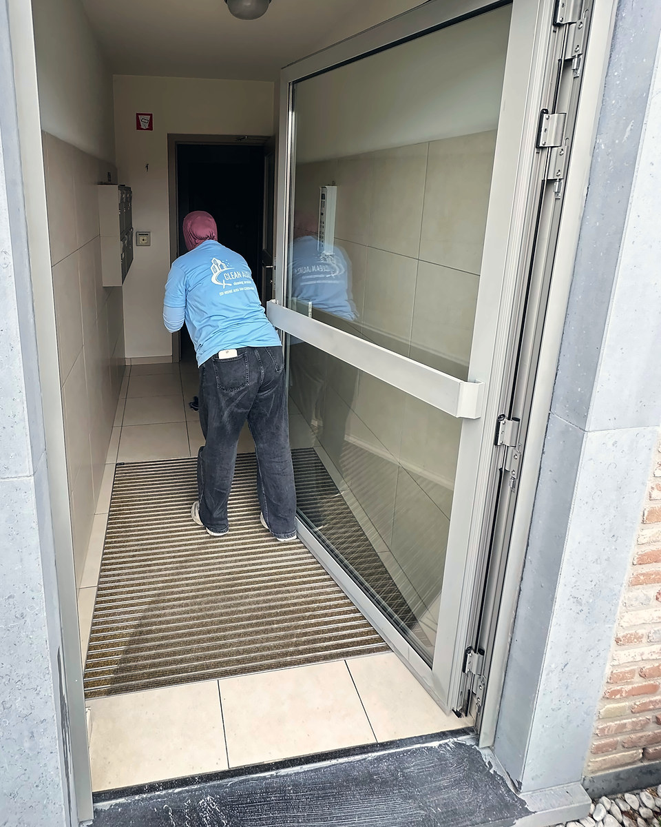 Clean Aura medewerkster reinigt de inkomhal van een appartementsgebouw
