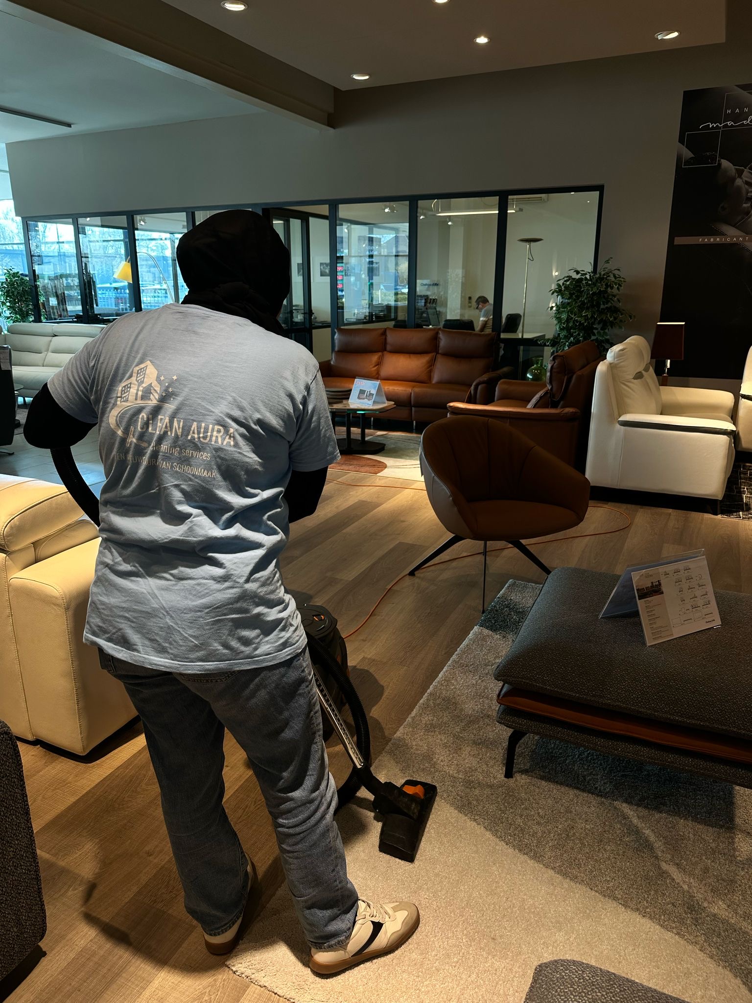 Clean Aura medewerker stofzuigt het tapijt van een meubelshowroom